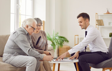 Obraz premium Elderly couple of clients signing a contract with a financial consultant. Couple commitment to their investment planning, guided by the professional advice and support of the agent.