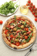 Tasty pizza with mushrooms, olives, tomatoes and arugula served on white textured table, flat lay