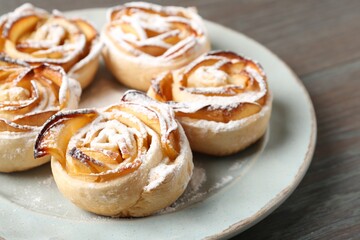 Freshly baked apple roses on wooden table, closeup