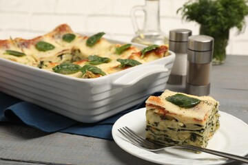 Delicious spinach lasagne on grey wooden table, closeup