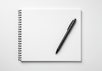 A spiral bound white notebook with a black pen placed diagonally on top isolated on white background
