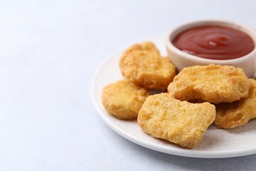 Tasty chicken nuggets with sauce on white background, closeup. Space for text