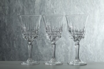 Three empty clean glasses on grey table