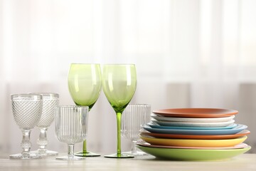 Empty clean glasses and plates on table indoors