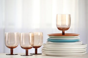 Empty clean glasses and plates on table indoors