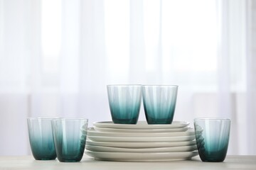 Empty clean glasses and plates on table indoors