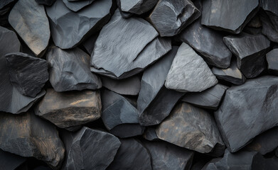 A close-up of dark grey rocks stacked together with a textured surface.