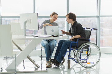 Fototapeta premium Colleagues business people woman man in chair for people with disability working on office. Startup business group team working together. Corporate professional team discussing project ideas