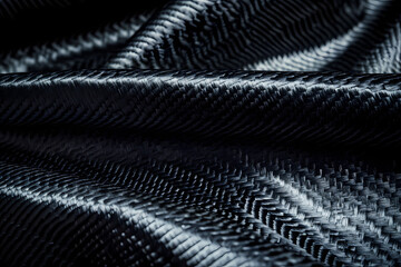 Black carbon fiber background, texture of dark gray fabric with a crosshatch pattern for a car interior or tech design