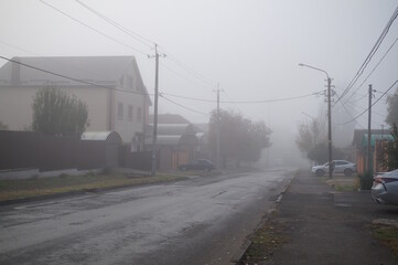 The city street is in a fog. Cloudy weather.