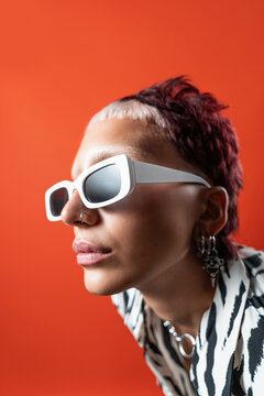 Fashion Model in Bold Animal Print, Orange Background, Sunglasses