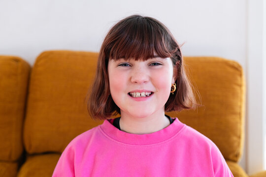 Girl smiling with missing milk teeth at home