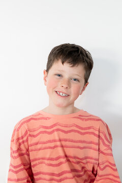 Young boy with missing milk teeth smiling at home