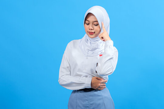 Indonesian senior high school girl in uniform, wearing a hijab, thinking with a confident expression. Education, intelligence, and concentration concept on a blue background.