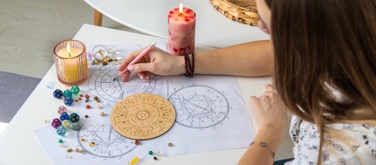 Woman astrologer draws a natal chart. Selective focus