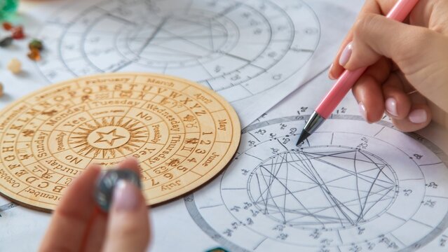 Woman numerologist astrologer counts numbers. Selective focus