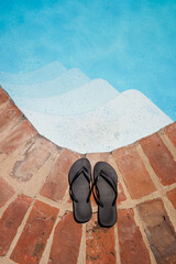 Flip flops by stairs of a swimming pool