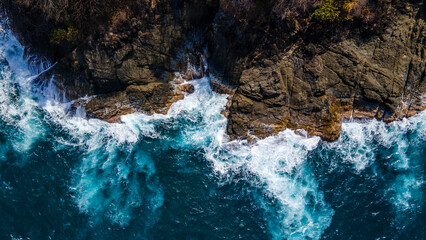 Aerial View of Turquoise Waves Crashing Against Rocky Coastline in Sapzurro, Choco, Colombia