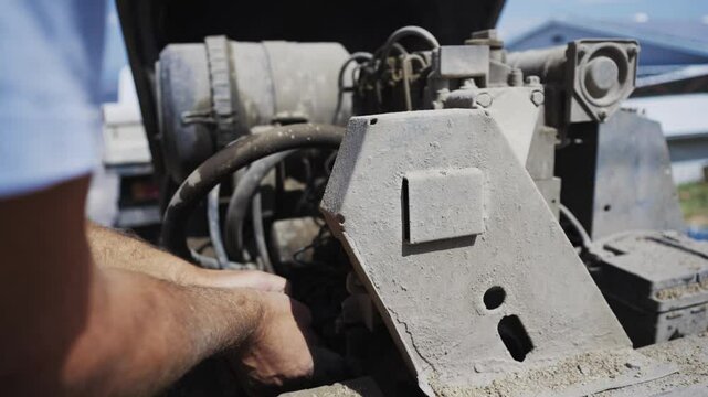 Close up view of a dusty industrial engine during operation of concrete pumping on construction site