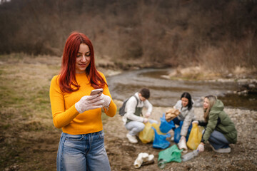 female teenager activist volunteer hold garbage and use cellphone