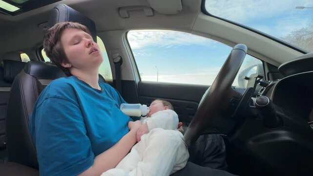 young mother of a newborn baby behind the wheel, driver, tired on the road. concept lack of sleep, feeding, driver