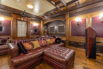 Luxury home theater interior design in classic style with lots of accessories. Comfortable leather sofas, wooden decor.