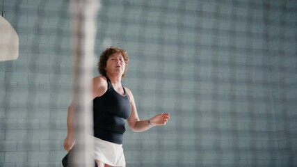 Adult pickleball players having a rally in a community gym