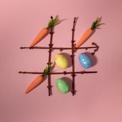 Tic tac toe with Easter elements carrots and eggs. Flat lay.