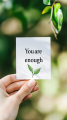Inspirational affirmation card held by hand with nature backdrop for motivation and positivity