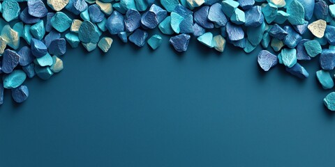 Colorful turquoise and gold decorative stones arranged on a blue surface for artistic or craft projects