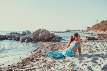 Young girl portrait in mermaid costume on the beach near sea