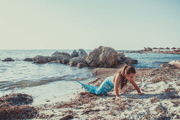 Young girl portrait in mermaid costume on the beach near sea
