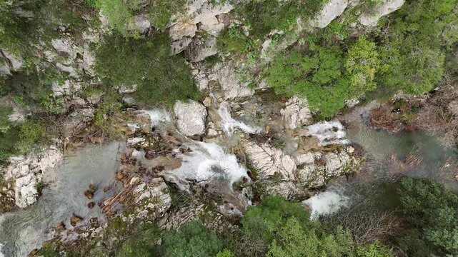 Aerial Top-Down View of cascade rushes down the rocky cliffs near Polylimnio Waterfall in Messinia, Greece after heavy rainfall