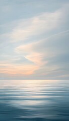 Fototapeta premium Calm ocean water reflects soft colors under a cloudy sky