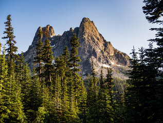 Sunset begins the rugged slopes of the Northern Cascade Mountains and old growth trees in Washington State