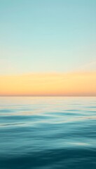 Obraz premium The ocean water reflects the sky with a soft sunrise glow