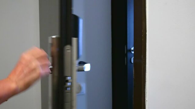 The woman opens the electronic lock of the hotel room with her card and enters the room. A magnetic smart key for unlocking doors. Protection and safety system