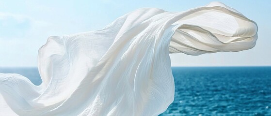 A white cloth floats freely with the blue ocean and sky