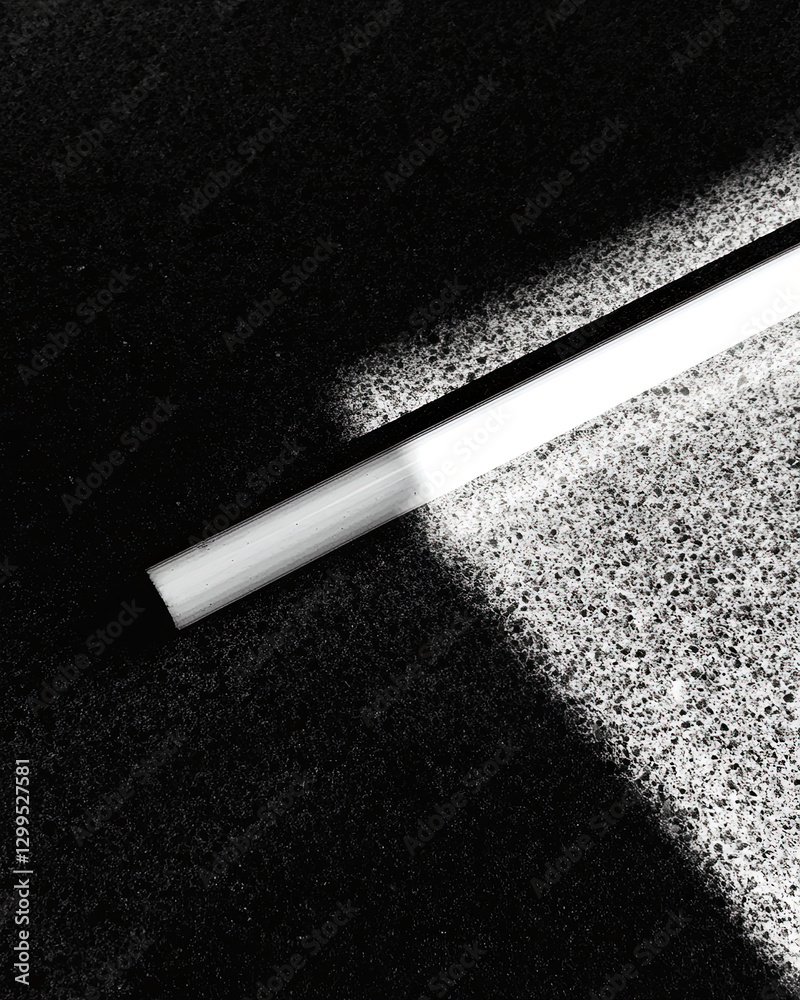 Poster strength and simplicity represented by a white cane resting on a surface and casting a bold shadow