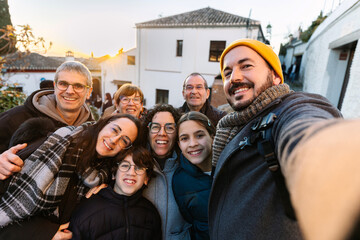 Multi generational caucasian family taking selfie portrait at city street. Happy group of people...