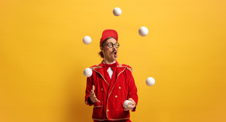 Entertainer in a red suit juggling with balls © Ljupco Smokovski