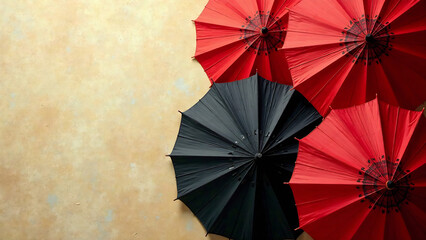 Close-up of a textured background featuring several printed parasols in red and black, with intricate designs. The parasols overlap on a beige, aged surface new falce image
