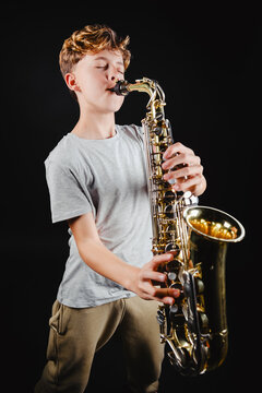 Teenage boy playing saxophone in a studio setting