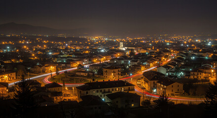Fototapeta premium Nighttime Aerial View of Urban Cityscape with Illuminated Roads and Buildings, Long Exposure Photography