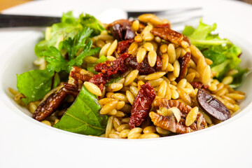 A freshly made Mediterranean orzo salad with sun-dried tomatoes, fresh basil, and Parmesan cheese.