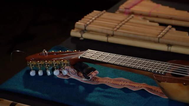 Close-up of Andean instruments like charango, wooden flutes, and percussion on textile.