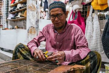 Balinese craftsman repair in bustling market setting