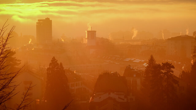 Atmospheric sunrise over Lausanne with urban silhouette