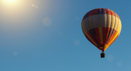 Fototapeta premium Colorful Hot Air Balloon Ascending in Clear Sky at Sunrise for Leisure and Adventure Travel