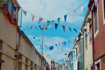 Festive bunting and lanterns decorate a narrow street for summer festival in June San Juan